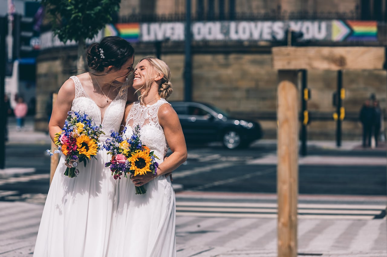 Two bride in Liverpool close to a pride banner