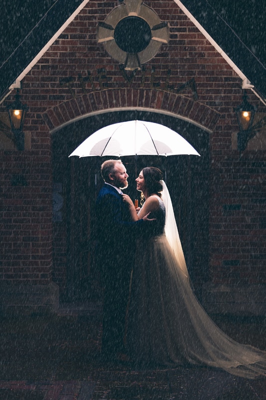 Bride and Groom outside of the Villa in the rain.